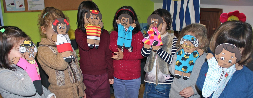 Niños con muñecos de tela que imitan a una familia